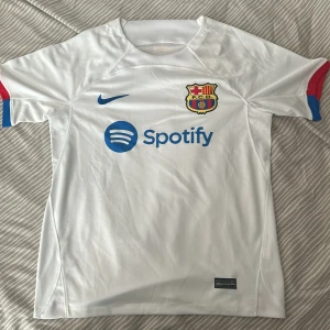 Barcelona bortatröja 23/24 - Jag säljer detta FC Barcelona bortaställ i storlek S. Tröjan är oanvänd med prislappen kvar. Säljs för 350kr.