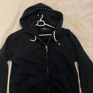 Morris Zip hoodie - En knappt använd hoodie från Morris. Stilren o fräsch i en marinblå färg. Säljes pga ingen användning.
