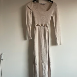 Stickad klänning med guldknappar - Stickad klänning med guldknappar, utbytta från vanliga beiga knappar. Zara; storlek XS