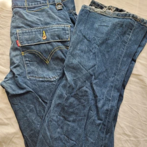 Levis jeans - Riktigt snygga levis jeans. Dom är märkblåa med gul sömm. Kunde inte få plats med fler bilder så kom gärna privat för fler. De är bootcut. Lite slitna där nere vid hälarna men annars i super bra skick! det står ingen storlek men passar mig m W30🙏🏻🥰🐊 