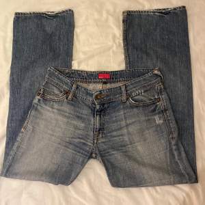 Ett par jättesnygga bootcut jeans med design på bakfickorna.