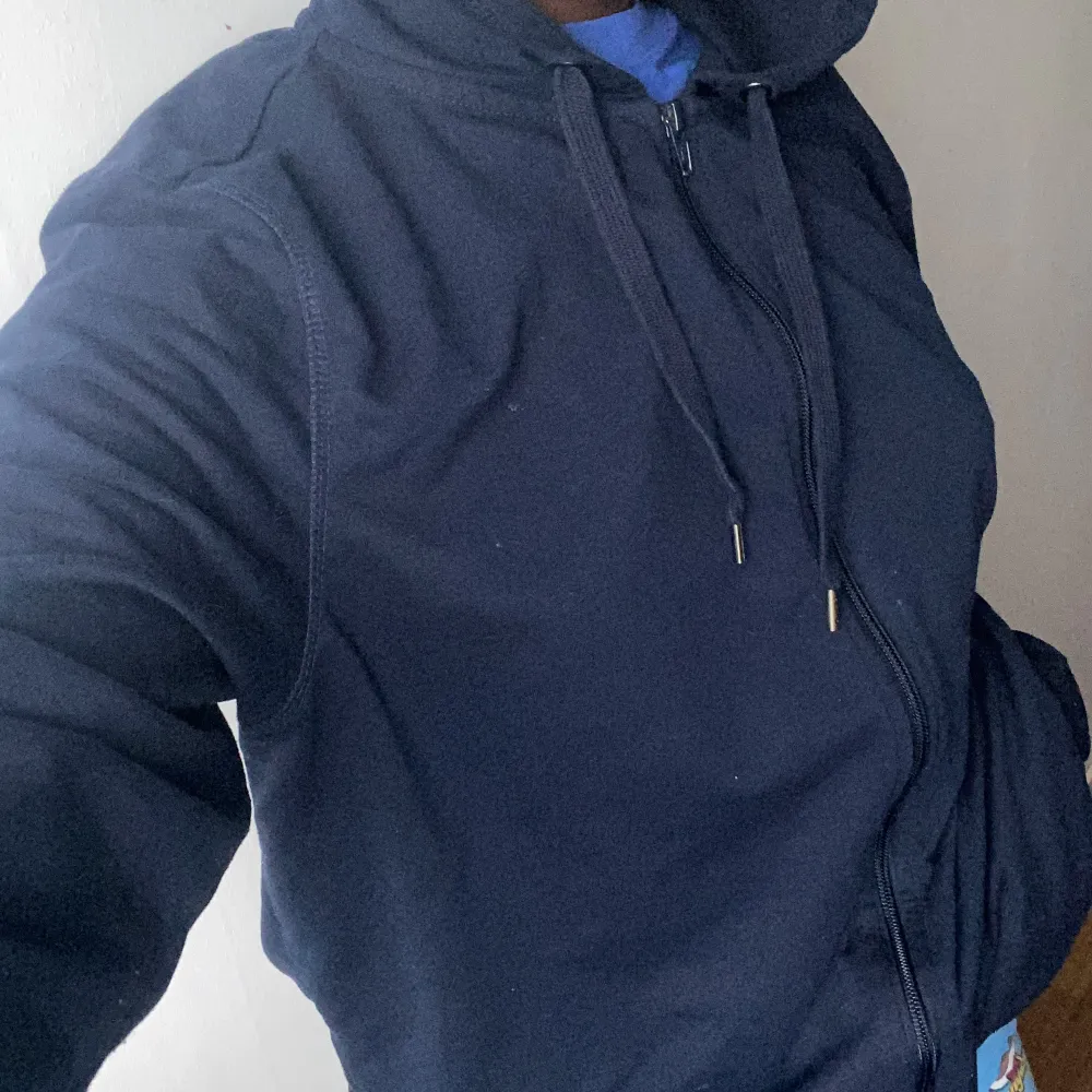 En mörkblå zip-up hoodie. Den är inte så tjock så den passar perfekt till hösten🍁. Hoodies.