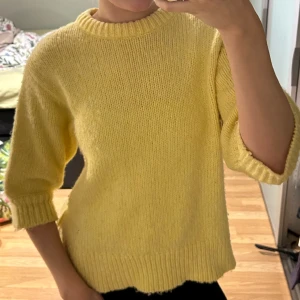 Stickad gul tröja - Stickad tröja från ginatricot med trekvartsarmar.