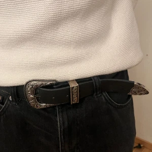 Svart bälte med silver spänne  - Svart bälte med silver spänne och fina detaljer,lite utsliten färg 💕