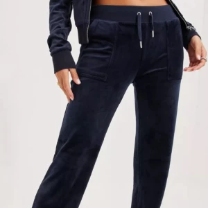 Mörk blåa juicy byxor - Hej detta är ett par mörk blåa juicy byxor, tyvärr så har ens metall grejen ramlat av så om du vill ha en bild på det så kan jag skicka det privat. Men annars är dom i bra skick.