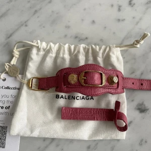 Balenciaga armband - Rosa armband med guld detaljer från Balenciaga i nyskick. Inköpt från Vestire Collective (aldrig använd) så finns både äkthetsbevis & kvitto. Storlek S (20cm). 