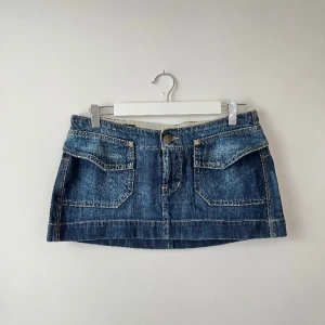 Minikjol - Lågmidjad minikjol från lee. Midjan är 40cm rakt över och längden på kjolen är 27 cm. I bra skick!