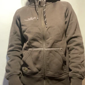 Snygg peak performance hoodie - Jättesnygg peak performance hoodie bruna med rosa detaljer. Nästan oanvänd, men i helt perfekt skick.  