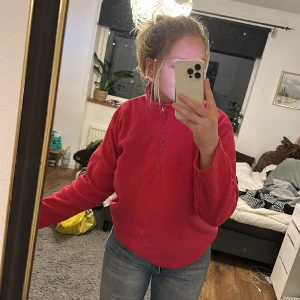 Fleece - Supersöt och mysig fleecetröja! Säljes då den inte används mer. Använt men relativt bra skick. Ett hål vid kanten längst ner (bild) samt några mer småhål längst ner. Inget som syns på håll dock. Finns gummiband längst ner att spänna den med, dock av.