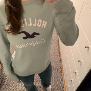 Tjocktröja - Säljer denna fina tjocktröja från hollister i en turkos/mint färg! Välanvänd och är därför lite nopprig och missfärgad därav priset