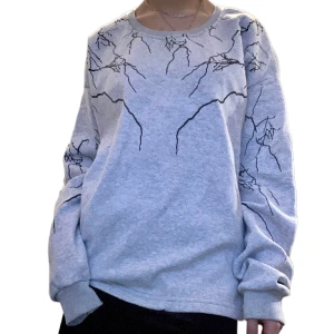 Sweatshirt - Helt oanvänd. Varmt och mjukt innetyg. Färgen på bild 2 stämmer bäst överens med verkligheten. Stl L men sitter lika väl som en M. Mönstret ska föreställa blixtar eller grenar antagligen🤨