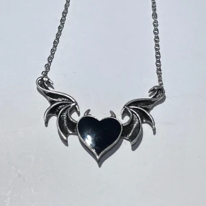 hjärta med vingar halsband - ett silver halsband med ett hjärta och vingar 🖤🪽  köpt från shein och är i fake silver och är väldigt gråaktigt. använd flitigt men är i relativt fint skick. frakt 18kr med swish, eller använd köp nu!