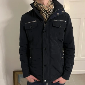 J Lindeberg Field Jacka - Vi säljer nu denna riktigt feta field jacka ifrån J Lindeberg i riktigt bra skick! Jackan har mindre lagningar som är osynliga vid användning. Priset är inte hugget i sten och kan diskuteras. Kan även passa någon som vanligtvis har L. Frågor i Dms!