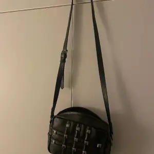 En svart väska ifrån Zara med ”silvriga ” nitar, använd fåtal gånger.