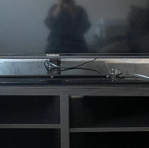 Tv+ Tv bänk - Välfungerande Tv är i bra skick 55 tum med HD osv. Tv bänk i mörk brun trä glas skiva ovanpå några repor på tv bänken. Tv pris 2000kr tv bänk 500