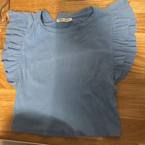 En blå tröja från zara med volanger. Kommer inte till användning och säljer därför. Storlek S men passar även M då den är strechig.