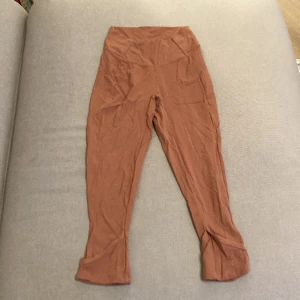 Gymshark tights - Orange-rosa tights från gymshark. De är 3/4-långa och har dekorativa hål vid bensluten som ses på sista bilden. Använda mindre än 5 gånger så i nyskick