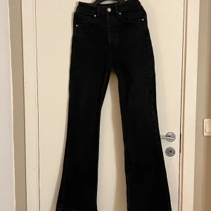 Bootcut jeans - Högmidjade svarta Boot Flare 980 Jeans med knappgylf och stretch. Storlek är 30 längd och 24 midja. Har fållat ner dem längst ner  