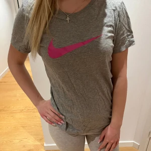 Grå Niketröja - Säljer min mörkgråa träningströja från Nike med rosa Nike-märke som inte kommer till användning💗sitter mer som en storlek S än M.