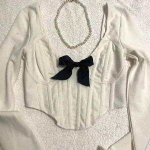 Korsett topp - Supersnygg korsett topp, JÄTTE bra kvalite! Det är dragkedja i ryggen. Finns en pytteliten svart fläck på vänstra ärmen därav priset<3 OBS accessoarerna ingår EJ (halsband, rosett) 