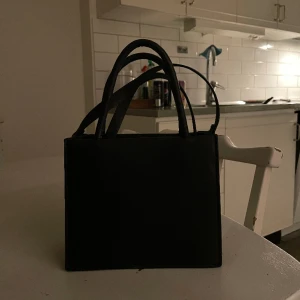 Svart väska - Hej! säljer min jätte snygga väska, som passar till alla tillfällen, den är rymlig och jätte fin att ha som handväska men även axelväska. Den är nyskick och inte använd men har inte kvar prislappen! Pris kan diskuteras vid snabb affär!💕 