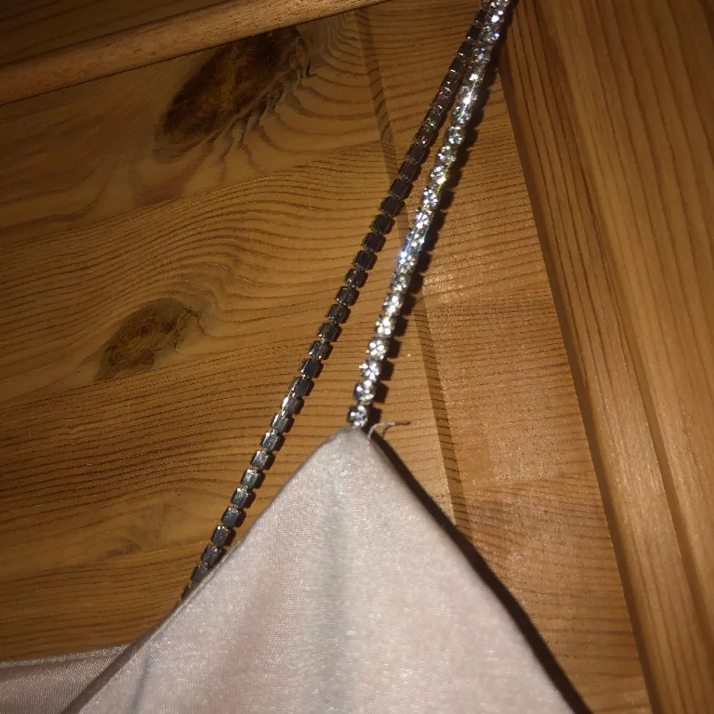 Glittrigt linne från New Yorker/Amisu. Ljus biege färg med glittriga kristaller som stroppar.  Endast provad, säljs då den är för liten för mig.. Toppar.