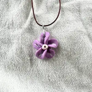 Vackert halsband med lila blomma. Justerbart band.