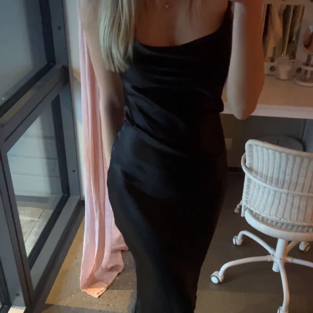 En super fin svart klänning i glansigt material , med fina detaljer i ryggen. Klänningen är aldrig använd. Perfekt till middagen eller kanske mösspåtagningen🖤. Klänningar.