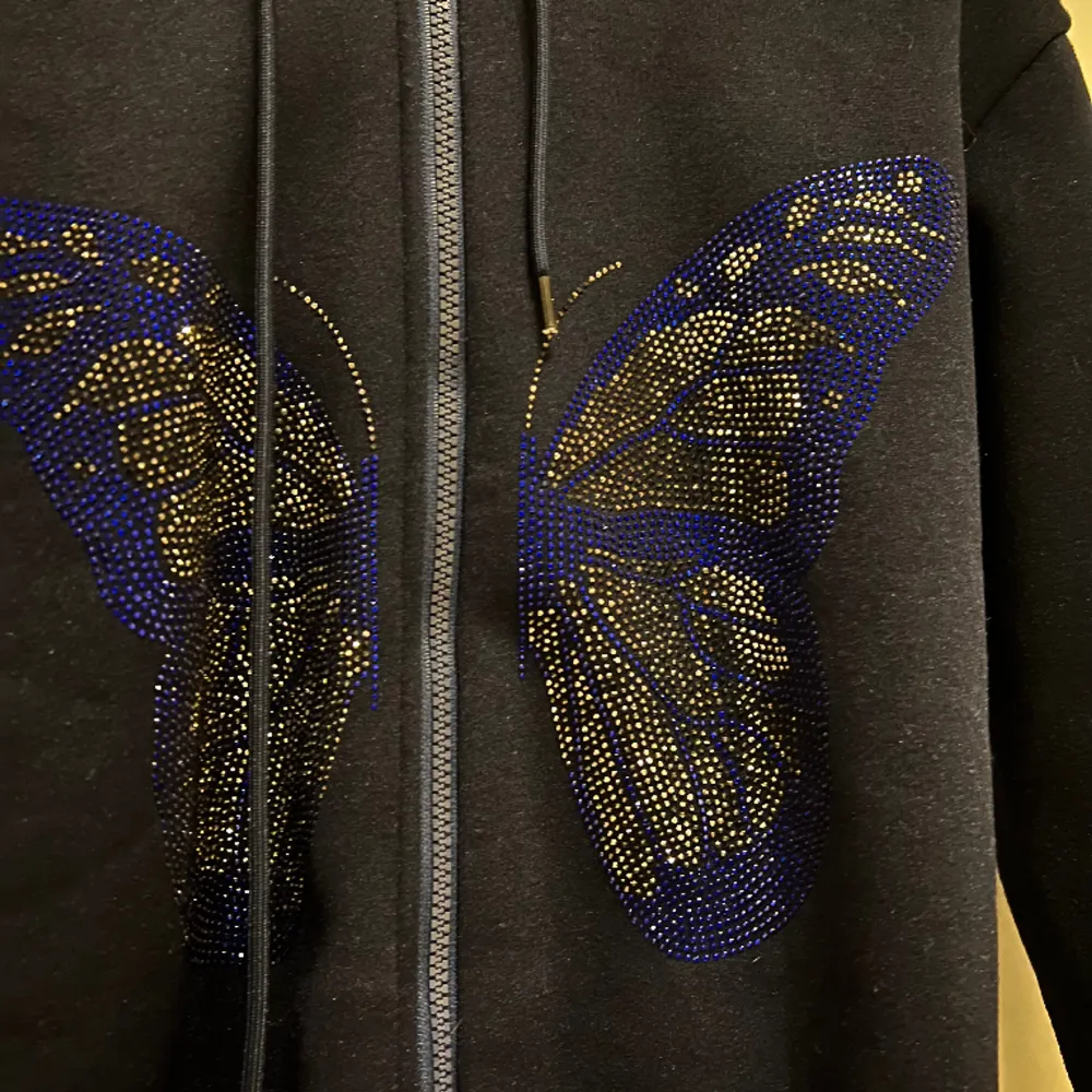 Mörkblå/svart hoodie med luva och en glittrig fjärilmotiv 3D STRL S. Hoodies.