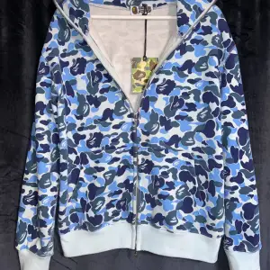 Säljer min jättefina bape hoodie i blå färg som är perfekt inför sommaren. Helt ny med tags och påse. Storlek S. Vid frågor så är det bara att kontakt. 