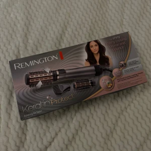 REMINGTON rotating air styler (varmluftsborste) - Två tempratursinställningar, kan ändra rotation med roteringabrytaren. 3 tillbehör. De två borstarna är försedda med keramiskt belagd yta med infuserad keratin och mandeloljan.  Använd 2 gånger, originalpris 699kr. Köparen står för frakt.