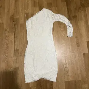En otroligt fin vit klänning med en arm, som passar perfekt till studenten. 