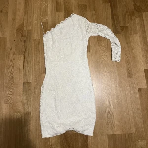 Vit klänning - En otroligt fin vit klänning med en arm, som passar perfekt till studenten. 