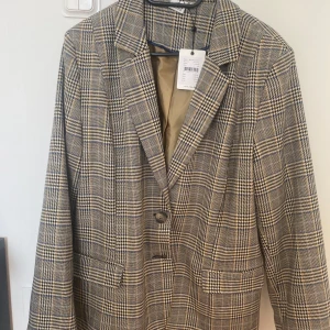 Rutig kavaj  - Jätte fin tidig vår/höst kavaj köpt men aldrig har andvänd. Prislappen är kvar 