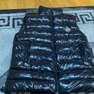Moncler väst - Hej just nu säljer jag min Moncler väst. Den är nästan oanvänd. Storlek 12. Jag kan mötas upp nånstans i Stockholm. Kan sänka priset lite. Tar bara Swish. 