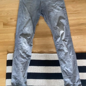 Jack & Jones jeans grå - Säljer nu ett par jeans från Jack & Jones i modellen slim fit. Liten defekt på höger knä, utöver det i fint skick!