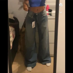 Jeans från Bershka - Blåa jeans i nyskick. Helt oanvända. Bilderna är lånade från förra säljaren! Färgen är mer blå irl. Skriv om du har frågor eller vill ha fler bilder. Köparen står för frakt