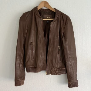 Läderjacka brun - Äkta Läderjacka brun från mango, strl 36. Sliten look. Säljes då den är för liten. MÄRKE: Mango 