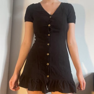 Svart sommarklänning - Så söt svart klänning med volang nertill och knappar. Lappen är bortklippt men ca storlek xs-s, lite för kort på mig som är 165 cm. Möts på söder eller postar. Skriv innan ni trycker på köp nu då jag är borta en del i sommar. 