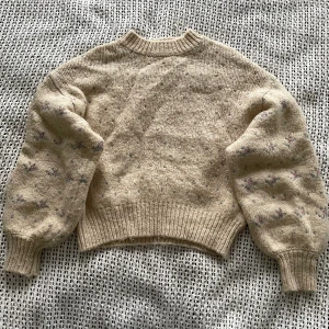 Stickad tröja med blommor  - Fin mjuk stickad tröja med små blommor på. Fint skick!