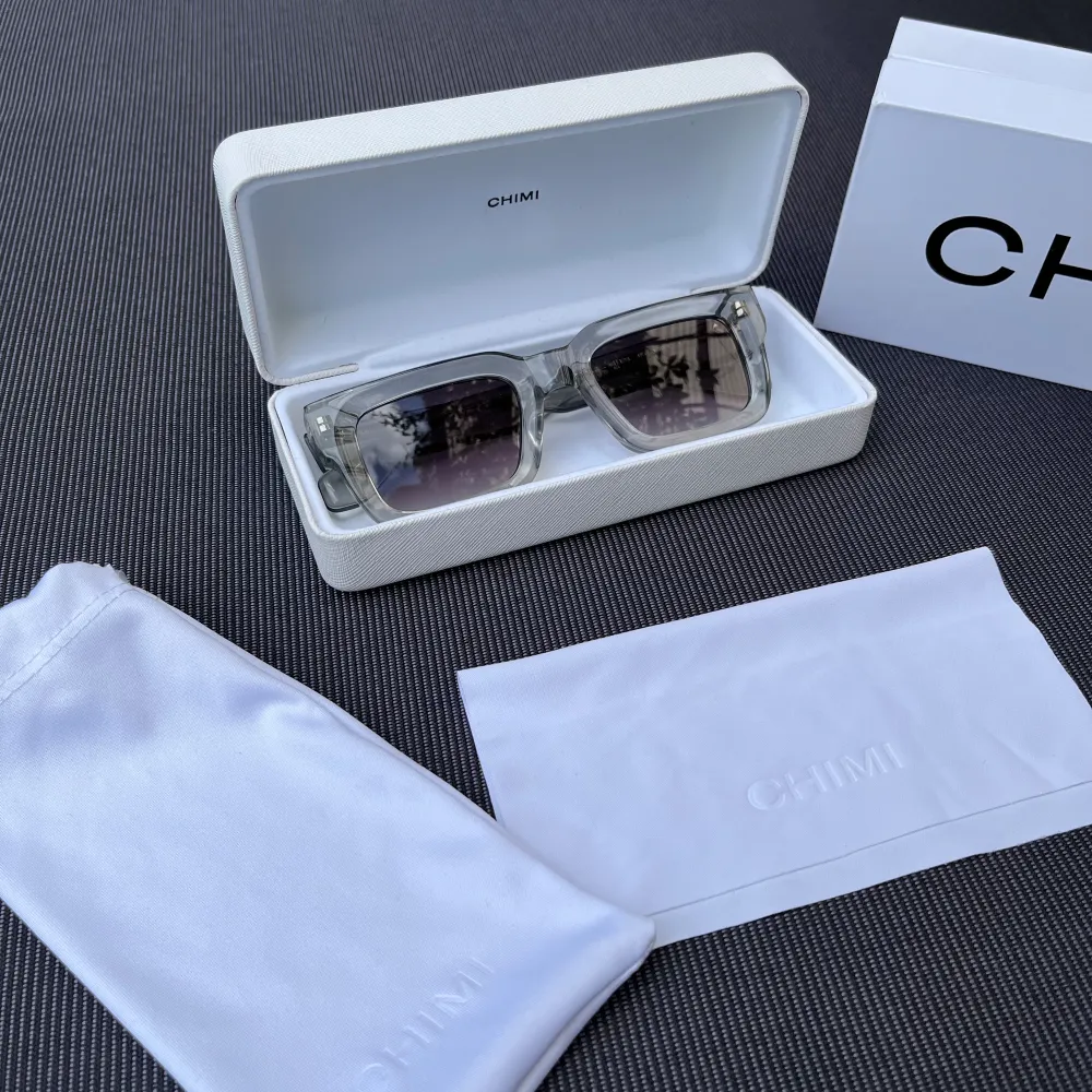 Säljer Chimi solglasögon, modell 05. Grå med mörka linser, nästan nya, endast använda några få gånger. Medföljer: originalfodral, putsduk och förvaringspåse. Perfekta för att ge din sommarstil ett lyft. Skydda ögonen med stil!   Pris kan diskuteras. Övrigt.