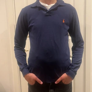 Polo Ralph lauren rugbytröja (slimfit) - Marinblå polo Ralph lauren rugbytröja, skick 9/10 inga defekter. Tröjan är M och slimfit. Modellen är 182 cm.