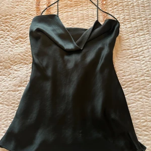 Svart satin Zara klänning - Kort Zara klänning, säljs då jag har ingen användning för den längre då jag har slutat dricka. Materialet är satin. Storlek L