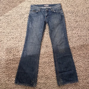 Lågmidjade jeans - Lågmidjade bootcut jeans med snygga slitningar där bak men som tyvärr inte kommer till användning. Midjemåttet är 39cm och innerbenslängden är 80cm💘💘(min kompis i bilden är 170cm)