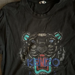 Kenzo T shirt - En Kenzo T shirt som jag aldrig använder. Säljer billigt därför. Storlek XS. Skrynklig bara för den inte används men kan stryka innan försäljning om du vill!😊