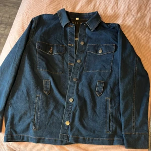 Stretchiga jeans jacka - Oanvänd jeansjacka med mycket stretch. Knyt band till midjan med följer