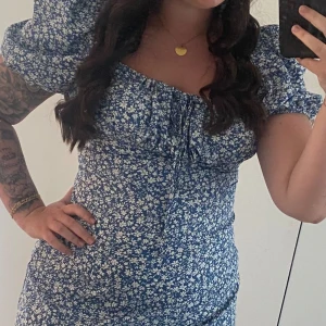 Blommig klänning - Figursydd klänning, det är en L men passar en liten Xl också! Har slits på vänster sida. Endast provad!