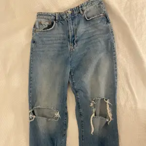 Ett par blåa straight leg jeans med hål för knäna köpa från Gina tricot i storleken 42!  Säljer pga av garderobsrensning.