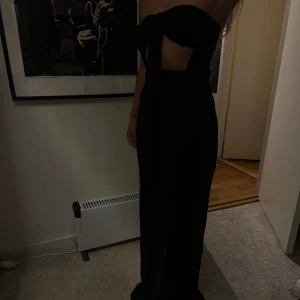 Svart Maxiklänning - Svart maxiklänning med slits. Använd 1 gång, i nyskick. Passar bra till en finmiddag eller fest