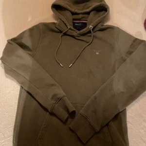 Hoodie GANT - Olivgrön hoodie från Gant. Ficka framtill på magen. Bra skick. 
